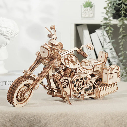 Wooden motorcycle model on a light surface with a blurred indoor background