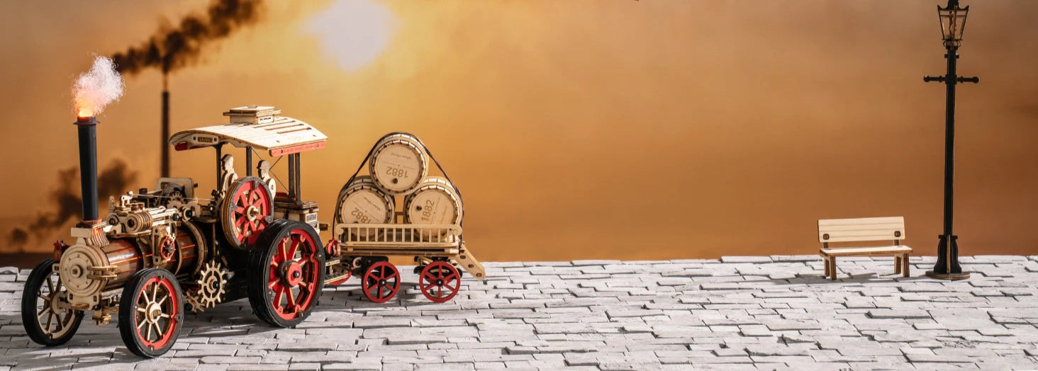 Model steam tractor on a brick platform with 'Piece by Piece, Joy Forever' text and a blurred background.