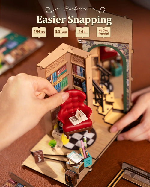 Handheld miniature bookshelf model with furniture and decorative items, labeled 'Easier Snapping' on a wooden surface.