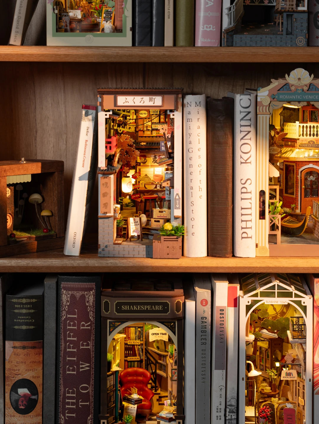 Miniature dioramas inside books on a wooden shelf