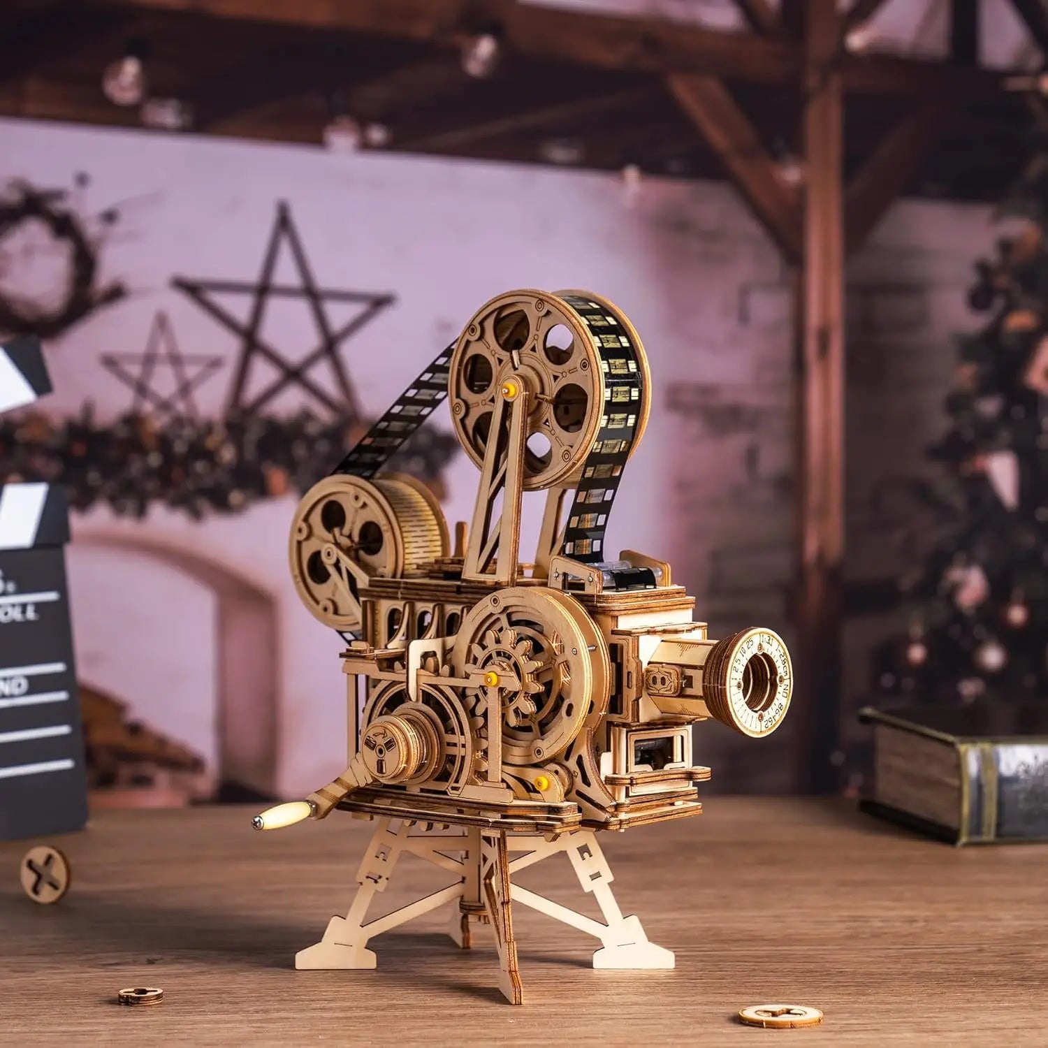 Wooden model of a vintage movie projector on a wooden surface with a blurred background.