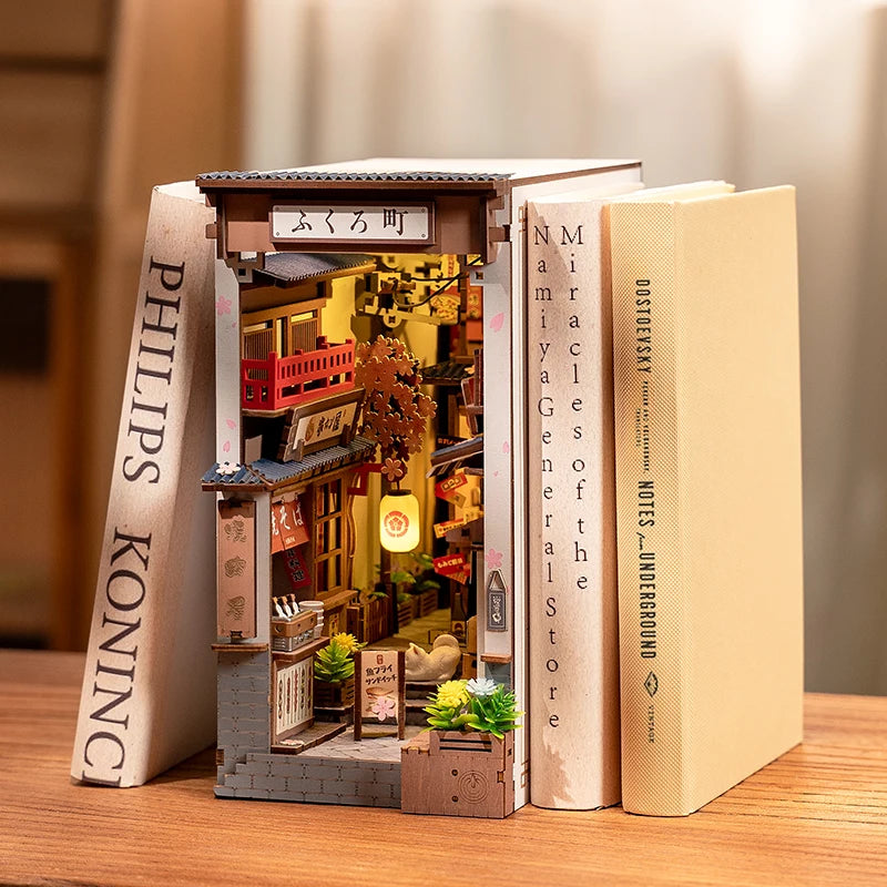 Miniature model of a store inside open books on a wooden surface