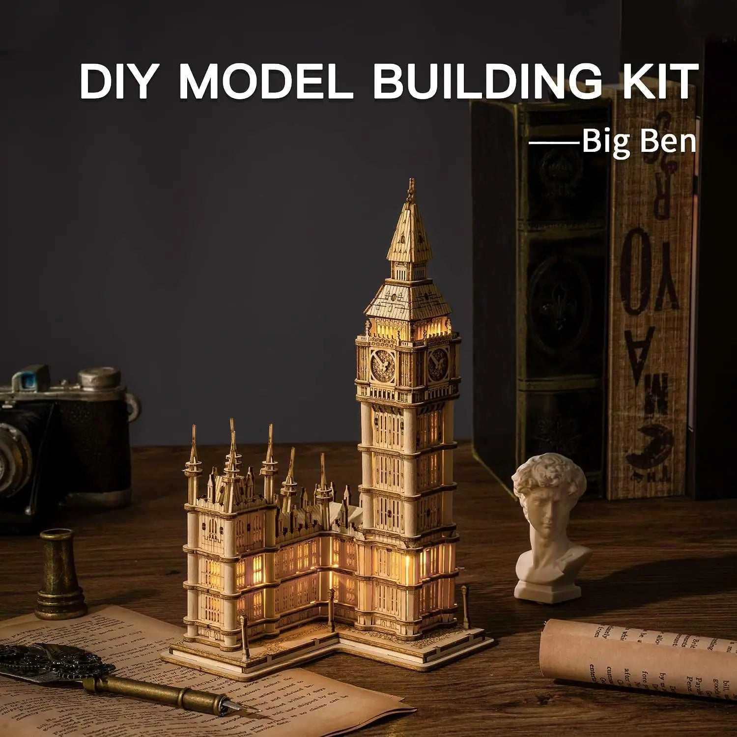 DIY model building kit of Big Ben on a wooden surface with vintage items.
